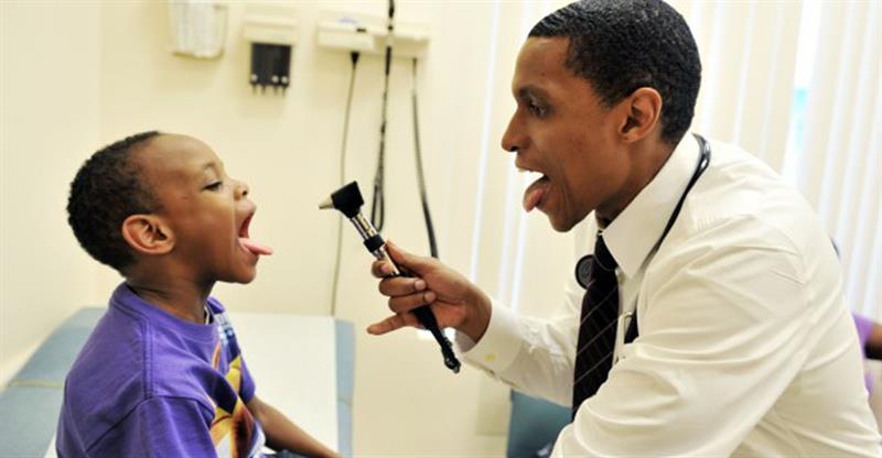 Doctor examines child's mouth