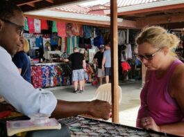 Female tourist patronises a craft vendor in Castries.