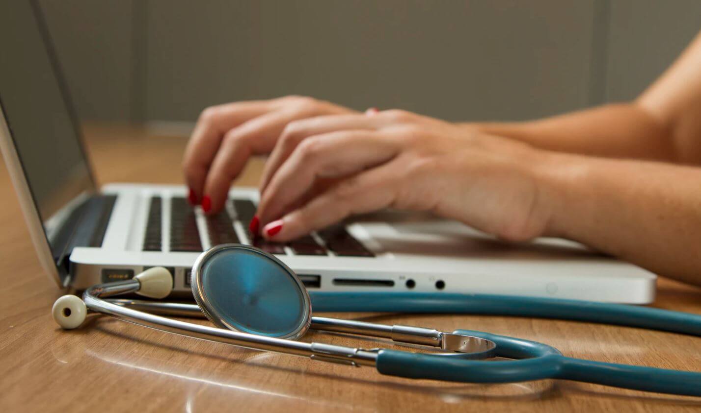 Medical professional at laptop computer.