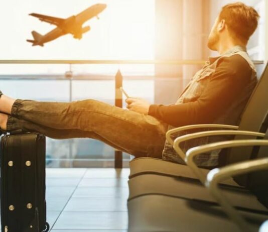 Traveller at airport watching plane take off