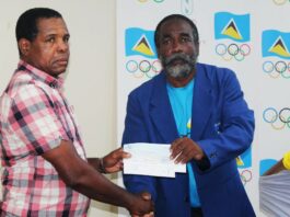 National Head Boxing Coach, Conrad Fredericks, left, receives the cheque from SLOC Inc. President, Alfred Emmanuel.