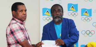 National Head Boxing Coach, Conrad Fredericks, left, receives the cheque from SLOC Inc. President, Alfred Emmanuel.