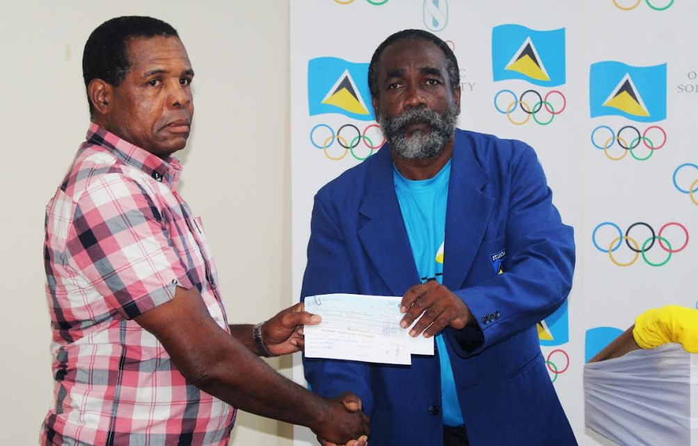 National Head Boxing Coach, Conrad Fredericks, left, receives the cheque from SLOC Inc. President, Alfred Emmanuel.