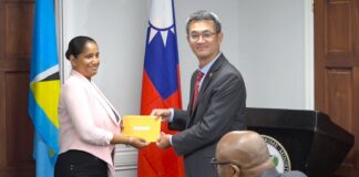 Taiwanese ambassador hands over funds to Saint Lucia official.