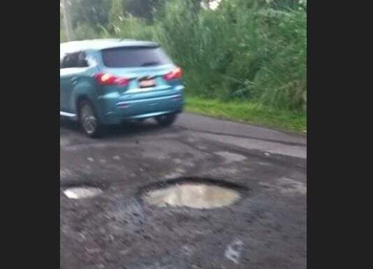 Vehicle passing on road with potholes