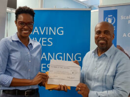 Minister Joachim Henry presents cheque.
