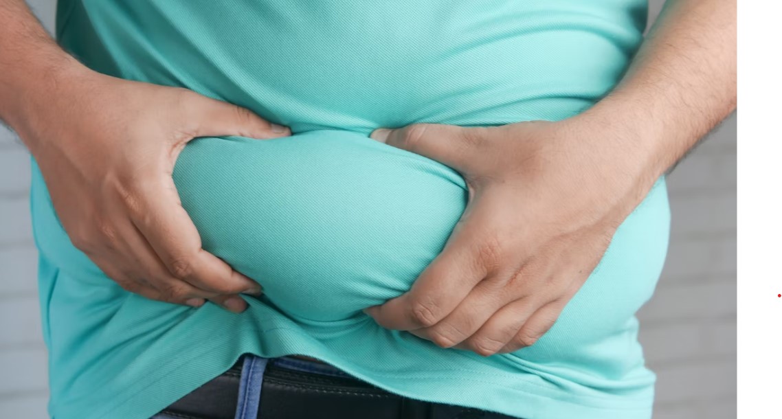Overweight man grabbing belly fat.