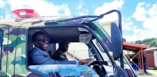 A grinning Prime Minister Philip J. Pierre takes a new police truck for a spin.