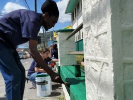 Volunteers painting the fence at the Canon Laurie Anglican Primary School in Castries.