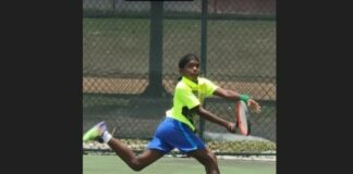 Alhil Cyril serves a return during a lawn tennis match.