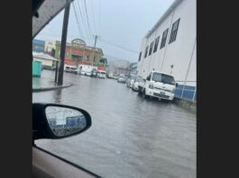 Vehicles parked on a flooded street in Castries during heavy rainfall.