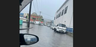 Vehicles parked on a flooded street in Castries during heavy rainfall.