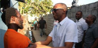 Philip J. Pierre interacts with a Vieux Fort resident during a visit to the community.