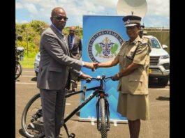 Prime Minister Philip J. Pierre and Police Commissioner Crusita Descartes-Pelius shake hands as he hands over a bicycle as part of a gift of resources in the fight against crime.