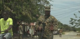 Armed police officer in camouflage uniform.
