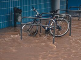 Flood waters encircle parked bicycle.