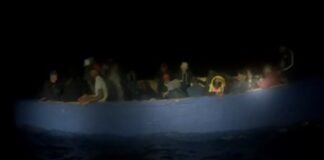 Illegal migrants in crowded small boat.