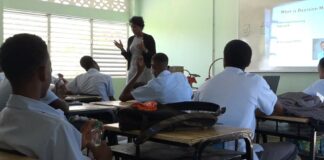 Teacher stands in front of class during drug abuse prevention session.