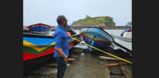 Prime Minister Philip J. Pierre stands amid fishing vessels hauled in from the sea to protect them from storm damage.