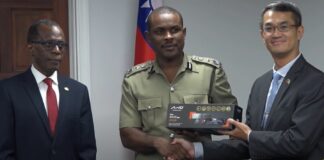 Taiwan Ambassador Peter Chen hands over surveillance equipment to Acting Police Commissioner Ronald Phillip while Prime Minister Philip J. Pierre looks on.