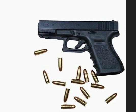 Glock pistol and ammunition against white background.