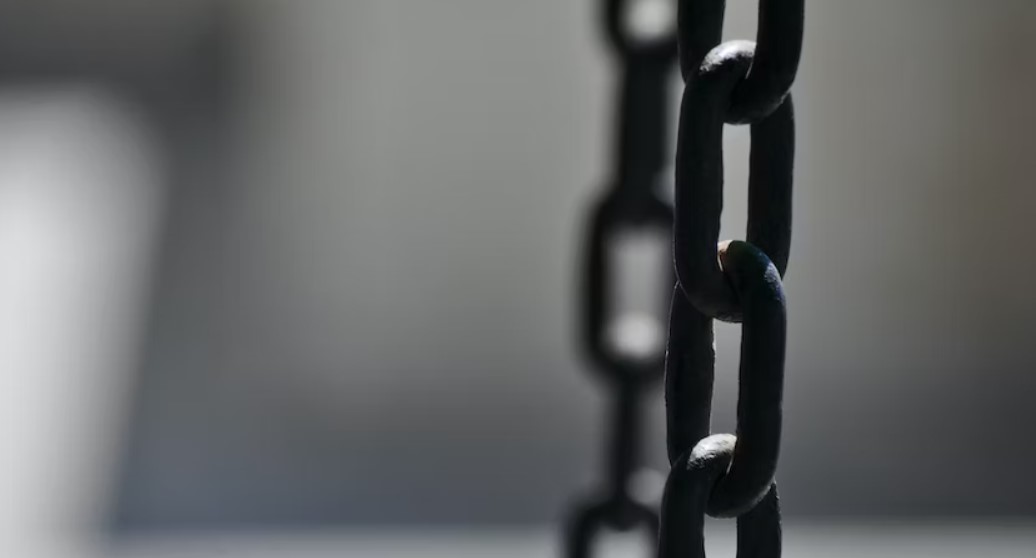 Black and white photo of metal chain depicting slavery.