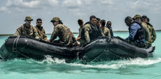 Military personnel on board two rubber rafts participating in Tradewinds 2022.