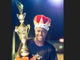 A beaming Ti Blacks wearing calypso crown and holding winner's trophy.