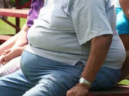 Obese man sitting on a bench.