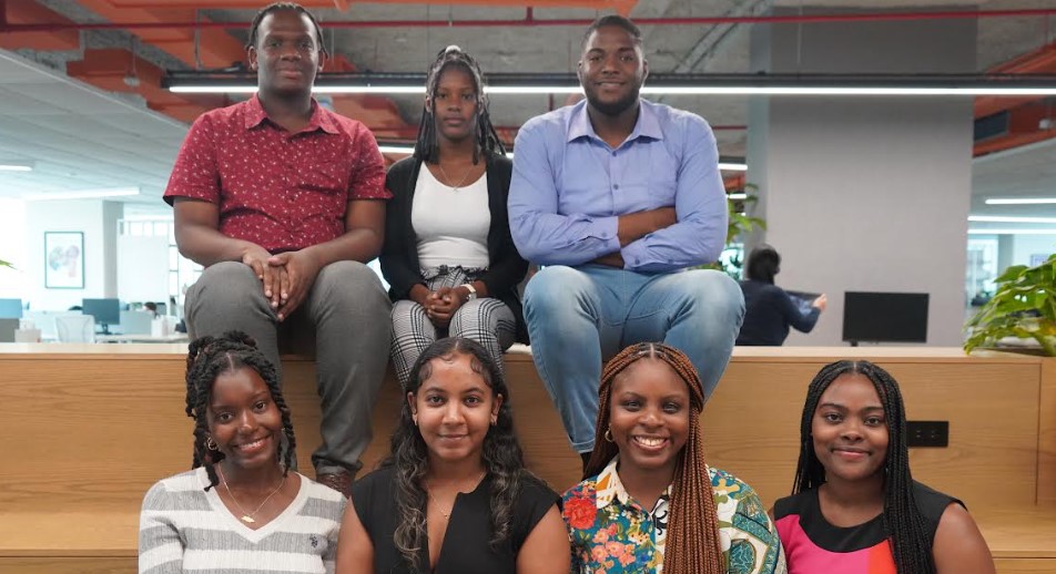 Seven young graduates recruited by C&W Communications pose for a photo.