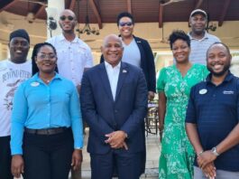 Dr. Ernest Hilaire and SLTA CEO pose with Saint Lucians working in TCI tourism industry.