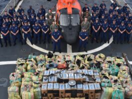 United States Coast Guard crew poses with seized illegal narcotics.