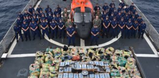 United States Coast Guard crew poses with seized illegal narcotics.
