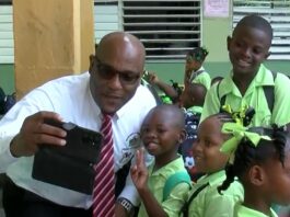 Education Minister Shawn Edward poses for a selfie with primary school students.