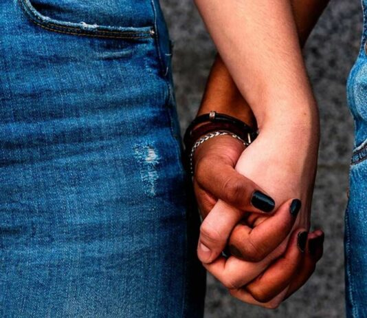 Couple in jeans holding hands.
