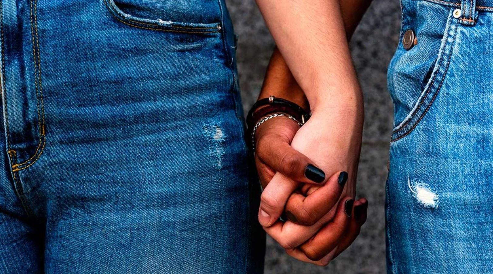 Couple in jeans holding hands.