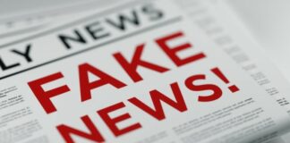 Folded newspaper with 'Fake News' written in bold red letters as a headline.