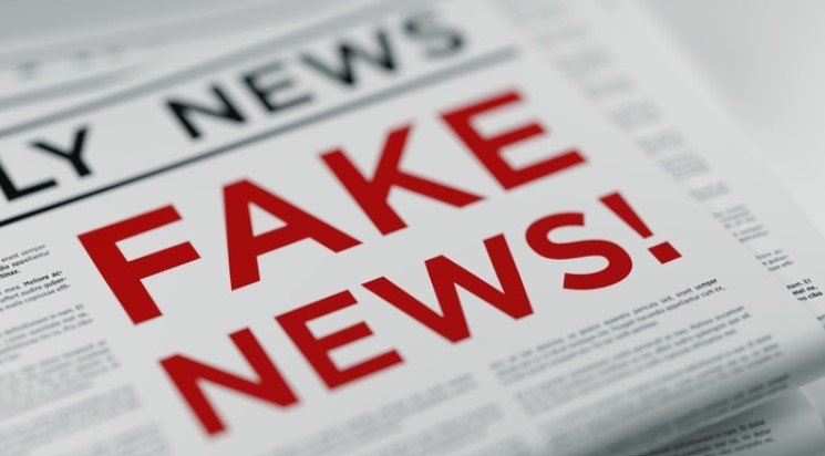 Folded newspaper with 'Fake News' written in bold red letters as a headline.