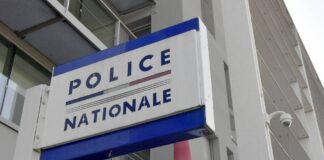'Police Nationale' sign in blue letters against white background hanging outside headquarters building.