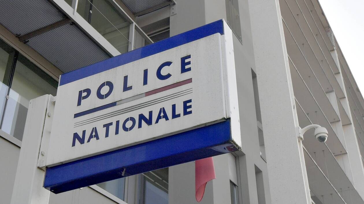 'Police Nationale' sign in blue letters against white background hanging outside headquarters building.