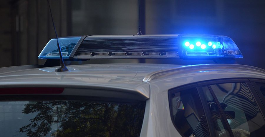 White police vehicle with flashing blue light.