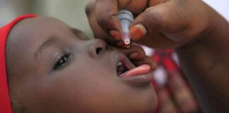 Child being administered polio vaccine by mouth.
