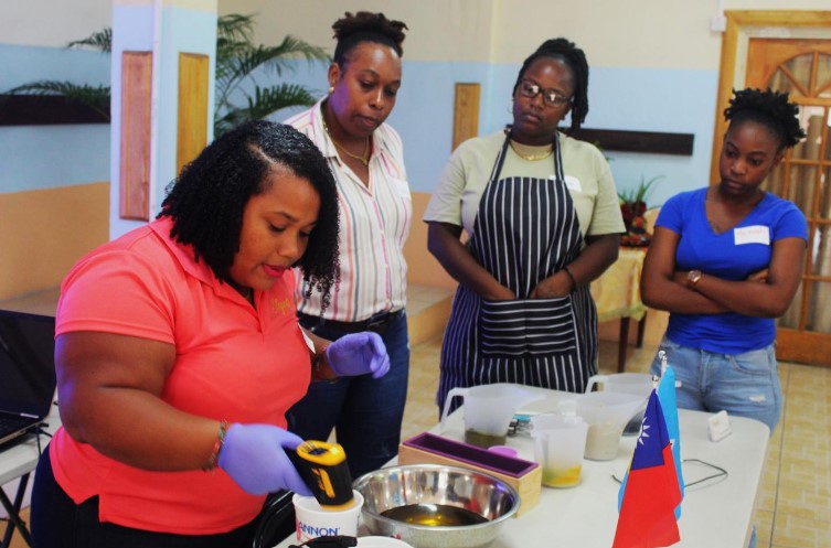PHOTO: Facilitator Kishma Louis (far left )demonstrating to participants how to mix ingredients in the soap-making process.