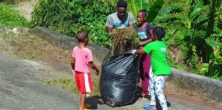 Youngsters bag garbage for disposal during community cleanup in Soufriere.
