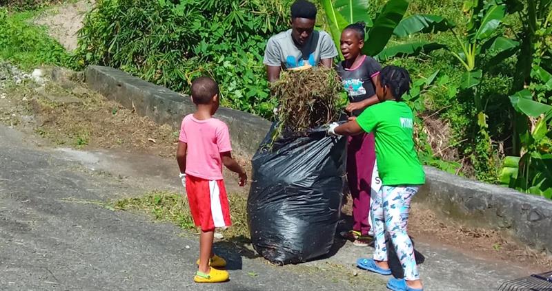 Youngsters bag garbage for disposal during community cleanup in Soufriere.