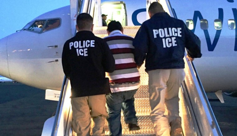 US Immigration officers escort an illegal immigrant aboard a chartered aircraft for deportation.