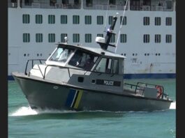 Marine Police vessel in Castries harbour in front of moored cruise ship.