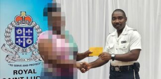 Police officer presents a cash voucher to a community member.