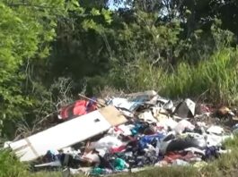 Vigier, Vieux Fort resident stands near pile of illegally dumped garbage.