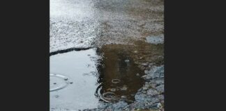 Pothole filled with water from falling rain.